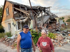 E.Butrimo nuotraukose: a) Nikolajus ir Valentina Kučerenkos liūdi prie sugriauto namo